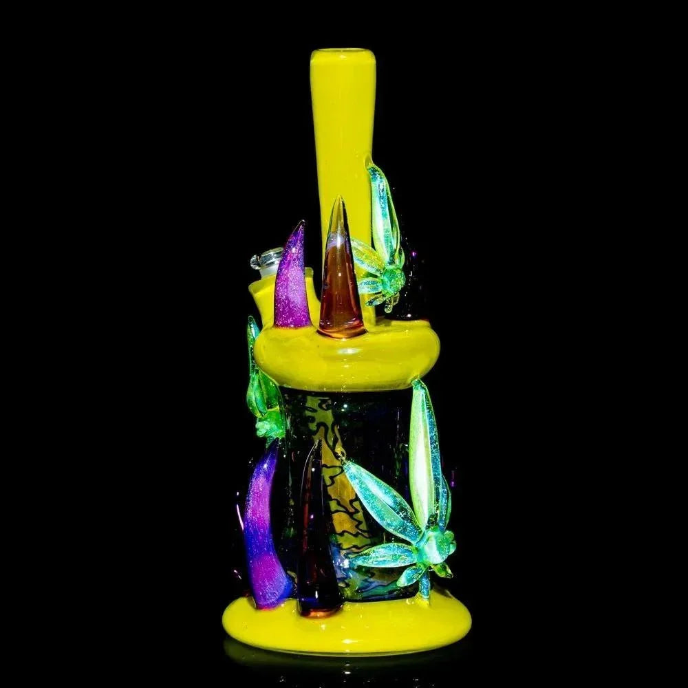 Colorful heady glass water pipe with yellow base, vibrant spikes, and decorative glass leaves.