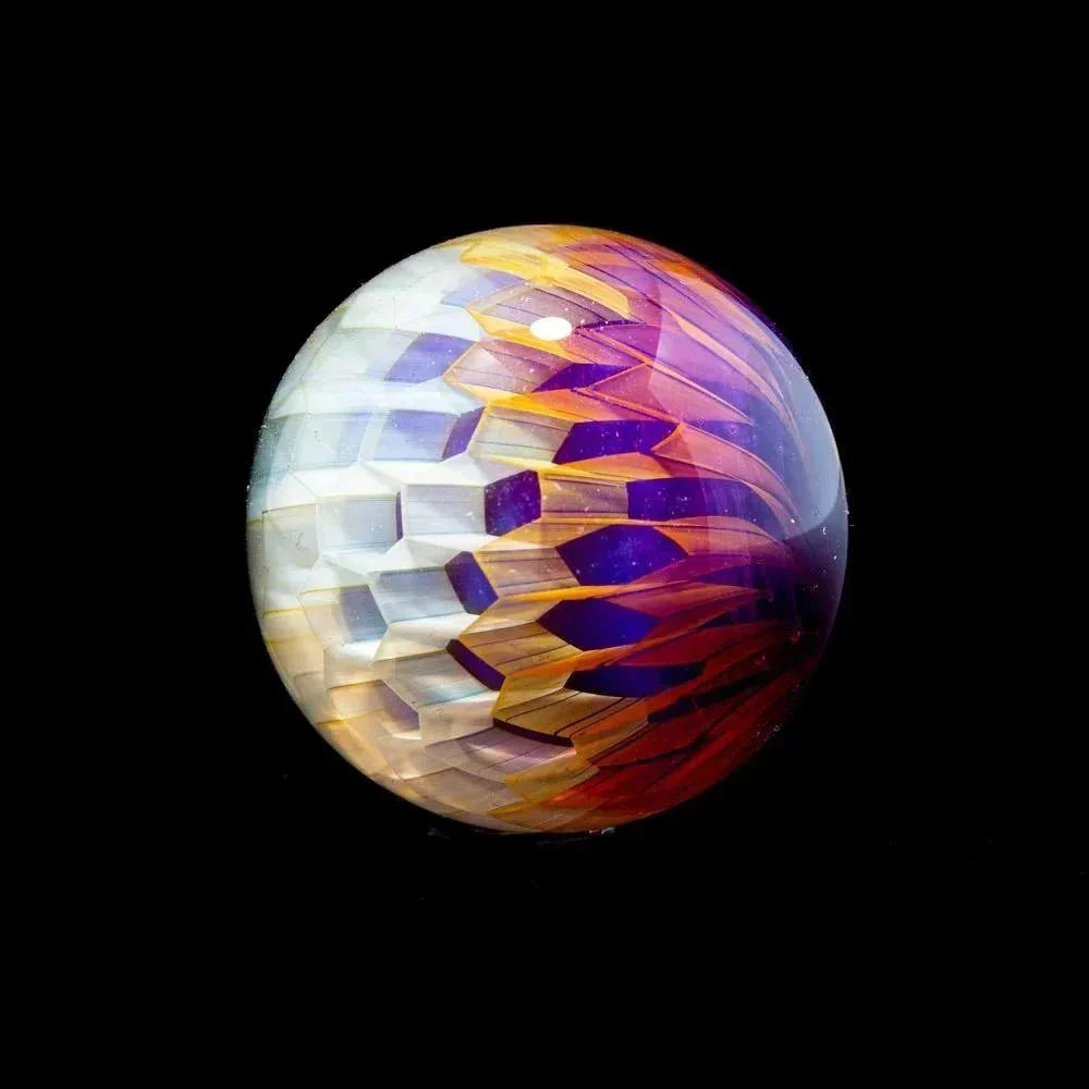 Colorful hand-blown glass marble with intricate geometric patterns on black background