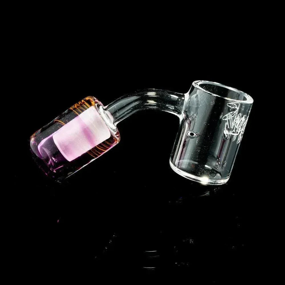 Clear glass quartz banger with pink accented joint and engraved design on black background.