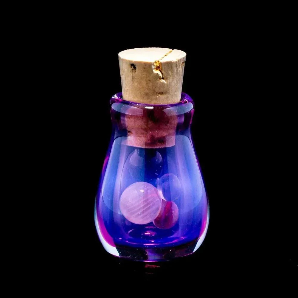 Purple glass stash jar with cork lid and marbles inside, on black background.