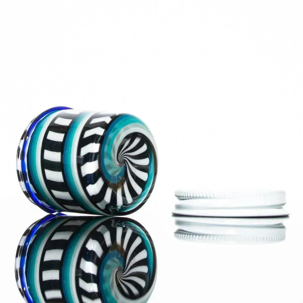 Double layer glass jar with black, white, and teal spiral linework, shown with lid off.
