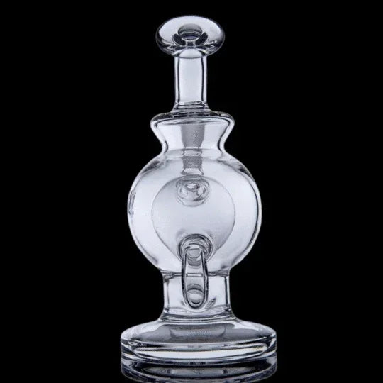 Clear glass carb cap with round chamber, directional airflow, and flat base on black background.