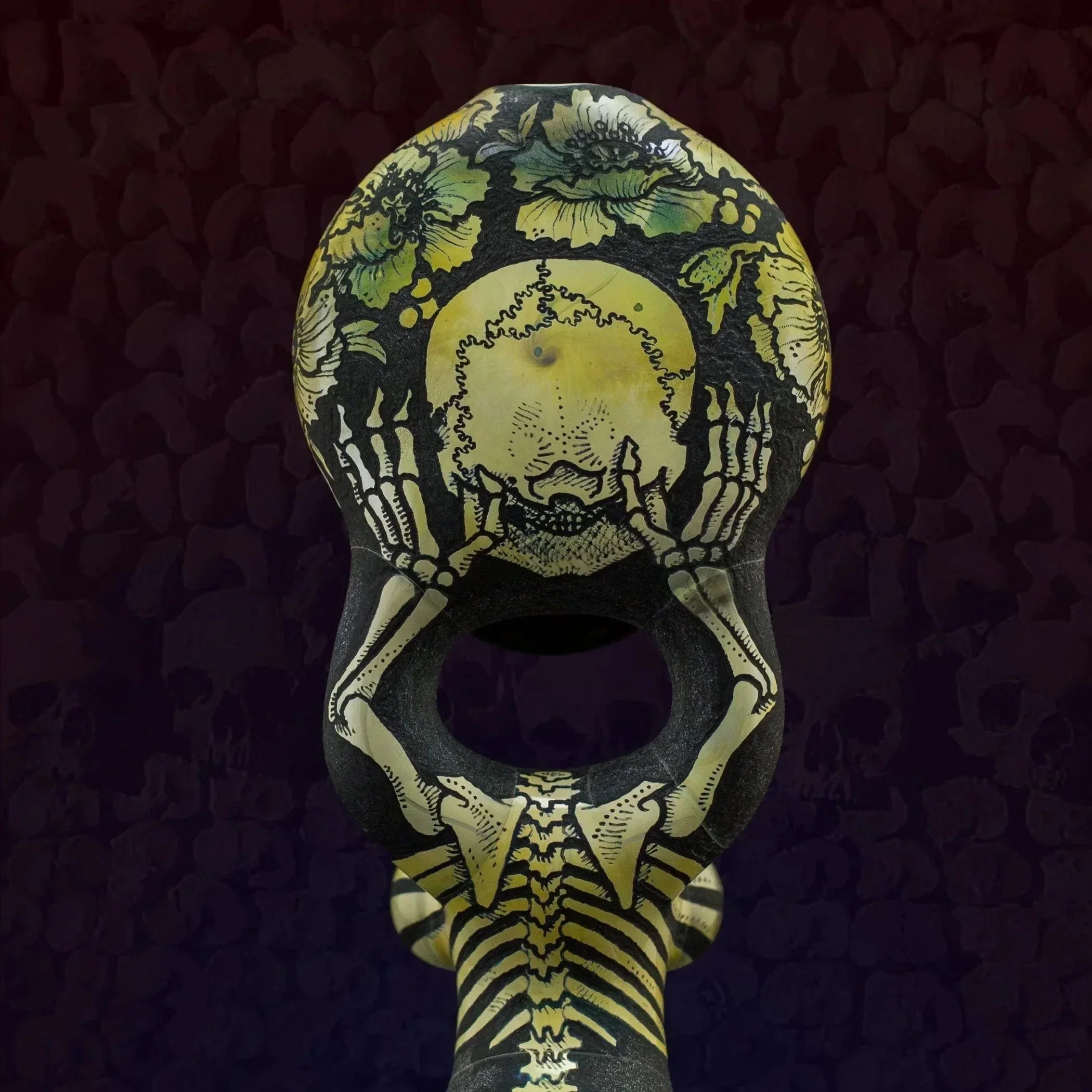 Heady glass pipe with skeleton and floral design, vibrant yellow and black artwork