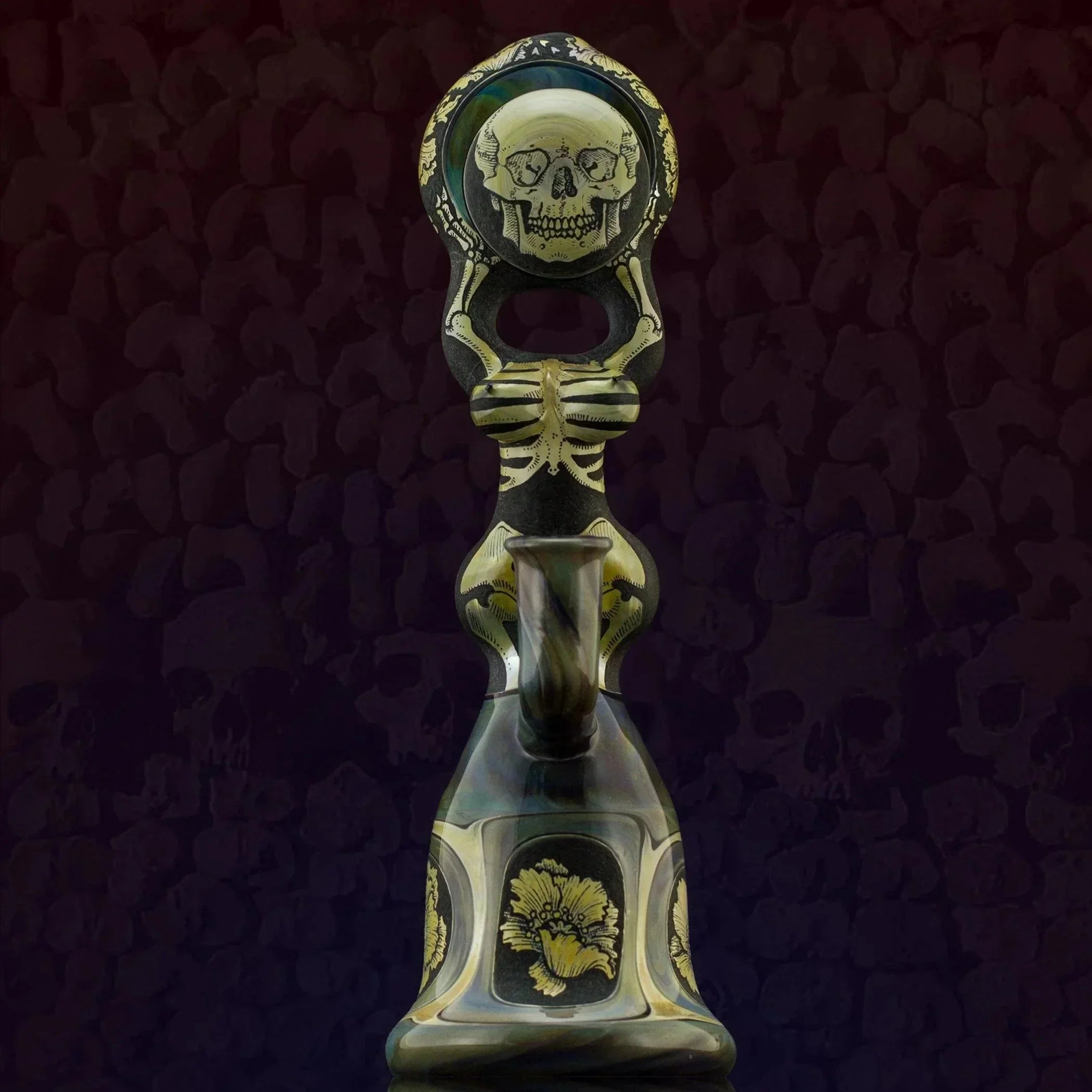 Skull-themed heady glass pipe with intricate gold detailing and floral accents