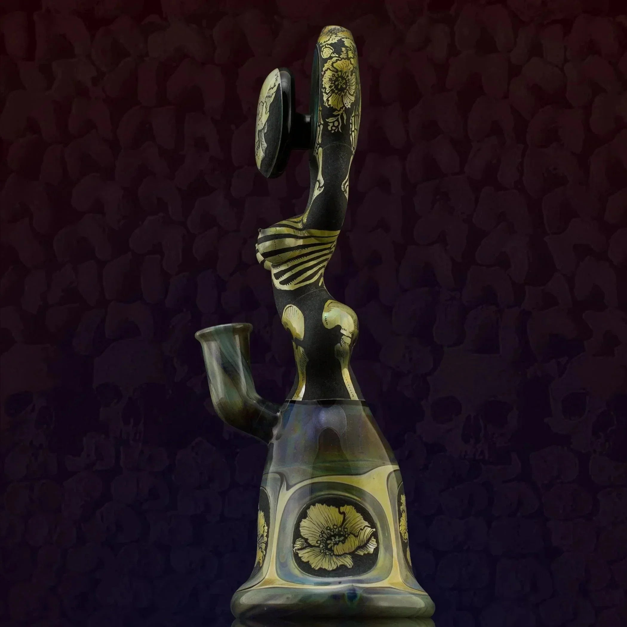 Artistic glass bong with gold floral designs and skeleton motifs, showcasing heady glass craftsmanship.