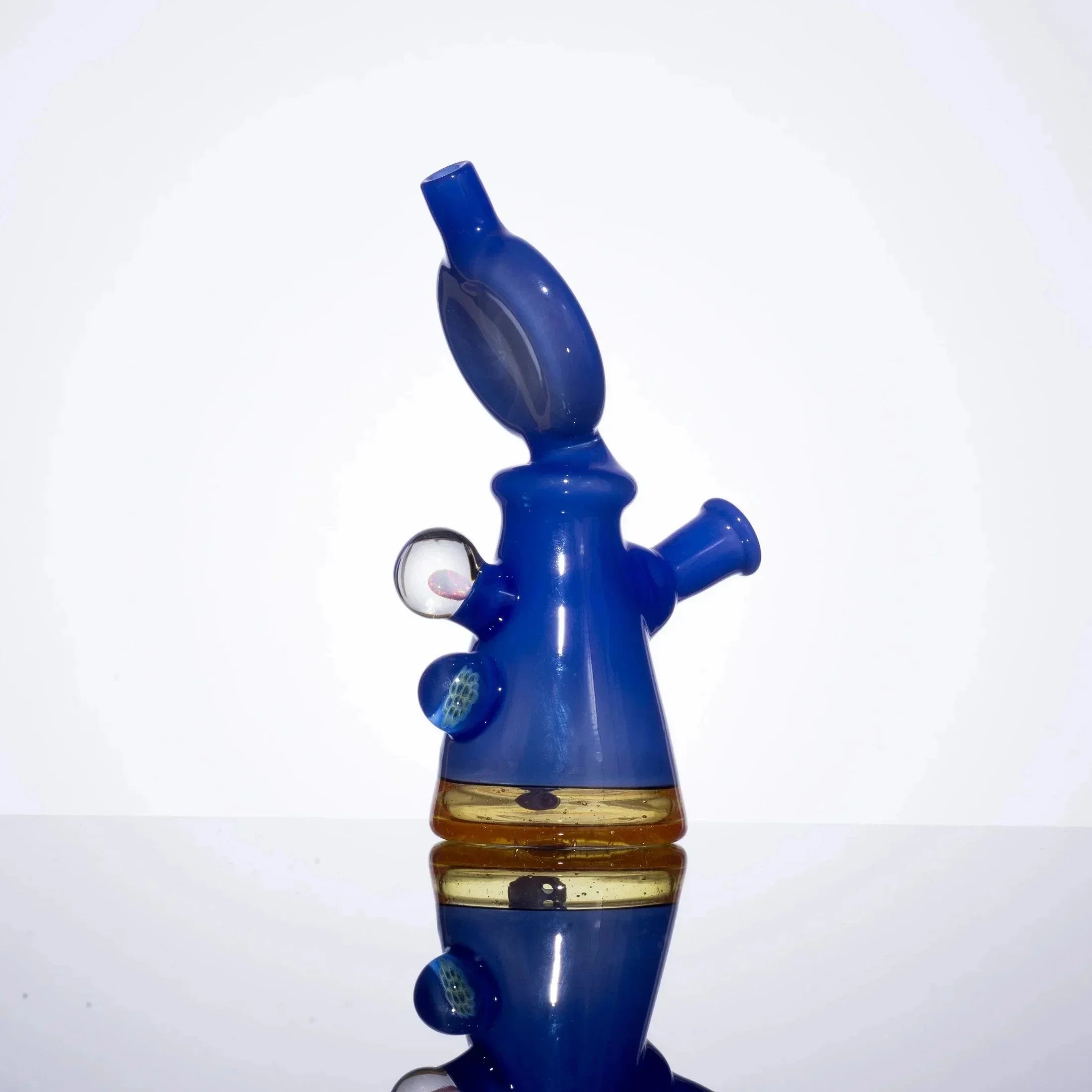 Blue and amber glass bubbler with intricate design, featuring side carb and decorative accents, ideal for heady glass collectors.