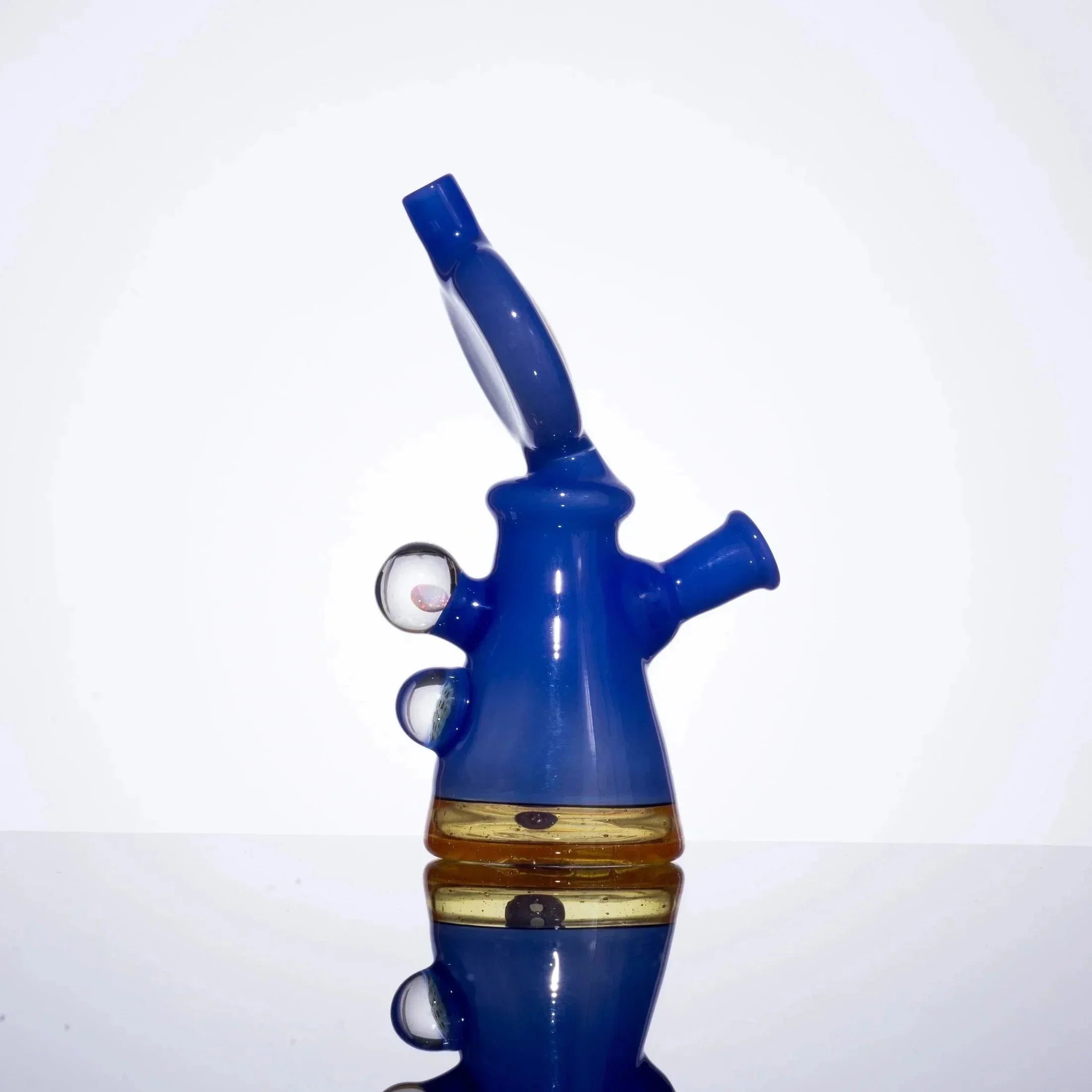 Vibrant blue glass bong with amber accents and bubble details, showcasing heady glass artistry.