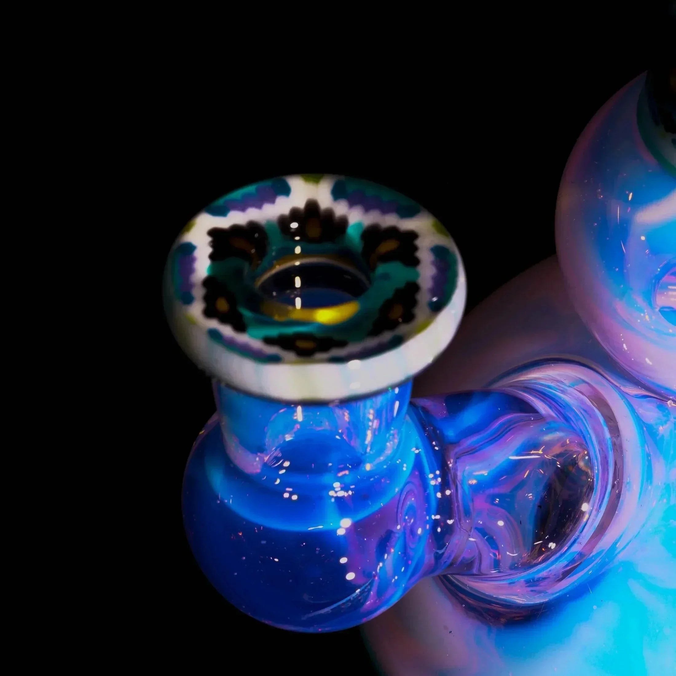 Close-up of a colorful hand-blown glass bong with intricate blue and white patterns