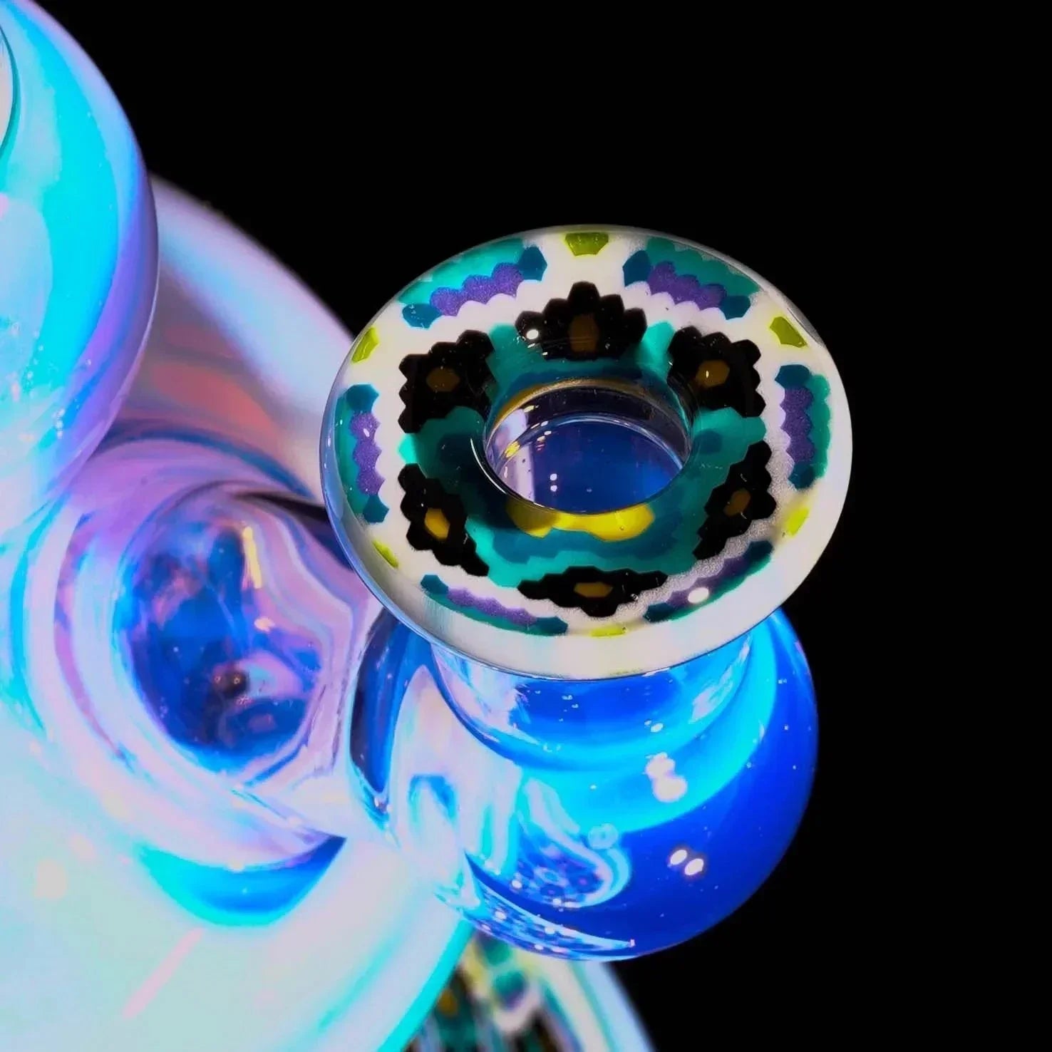 Close-up of a colorful heady glass pipe with intricate pattern and blue highlights