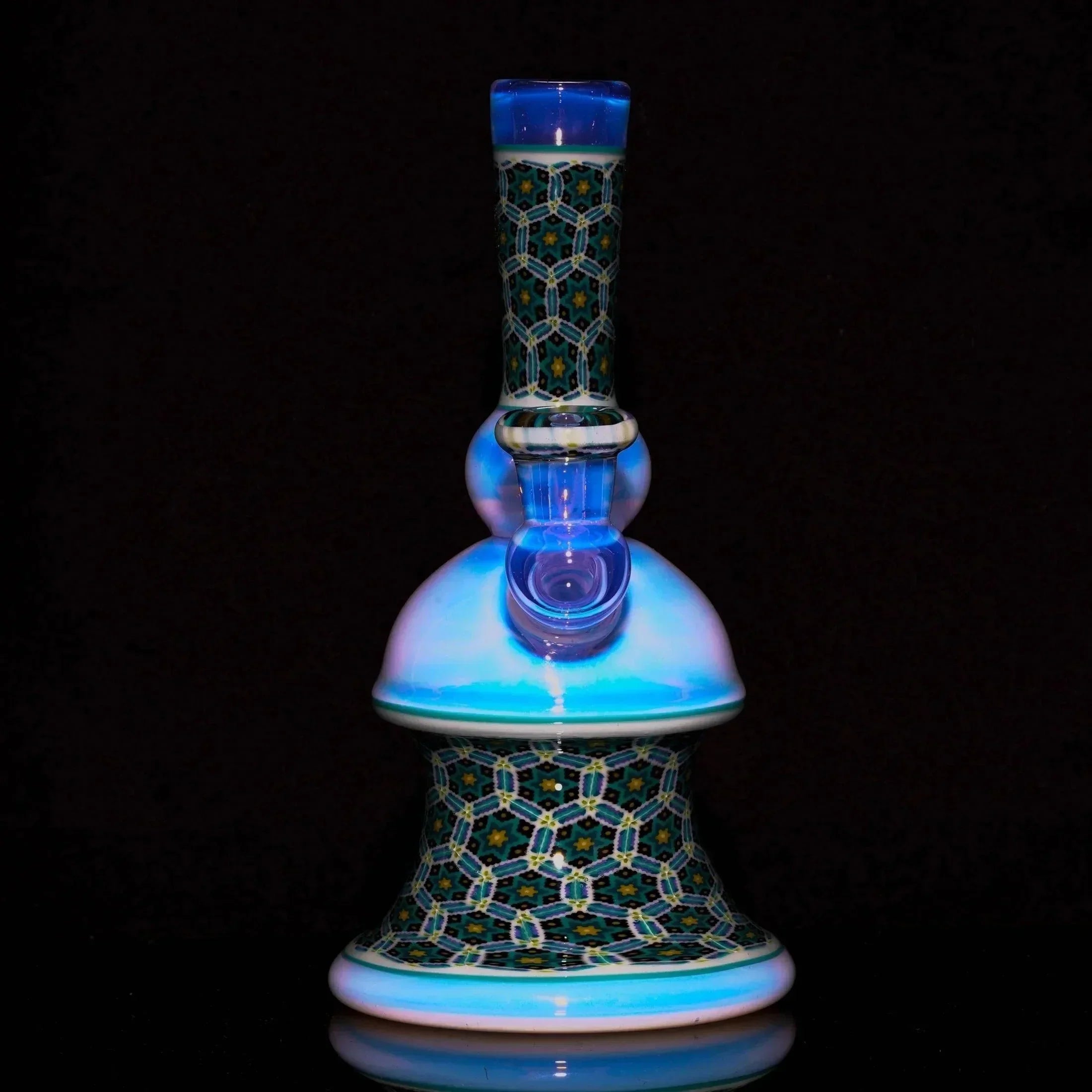 Intricate glass water pipe with blue accents and geometric patterns on a black background