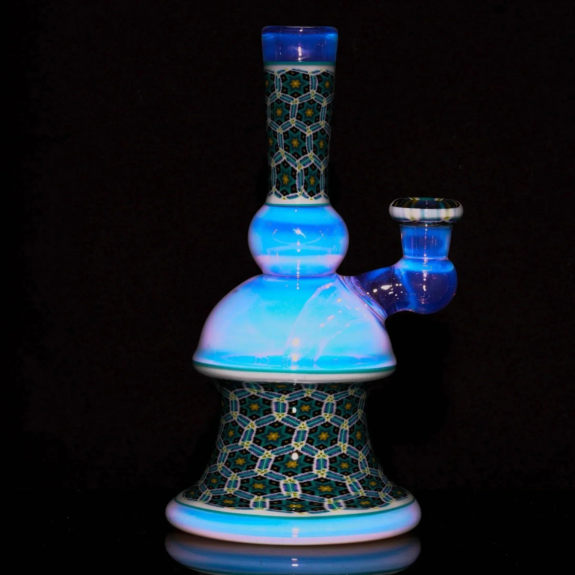 Intricate glass water pipe with blue and patterned mosaic design, displayed on black background