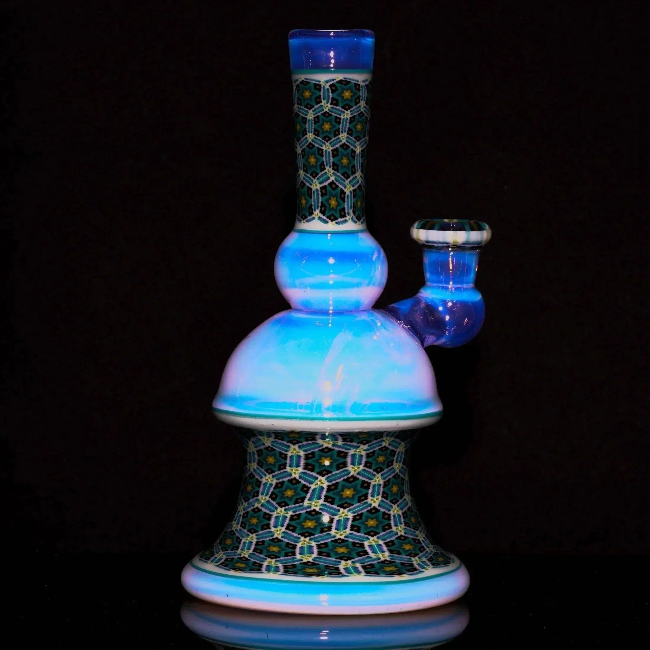 Intricate glass water pipe with blue and mosaic pattern details on a black background