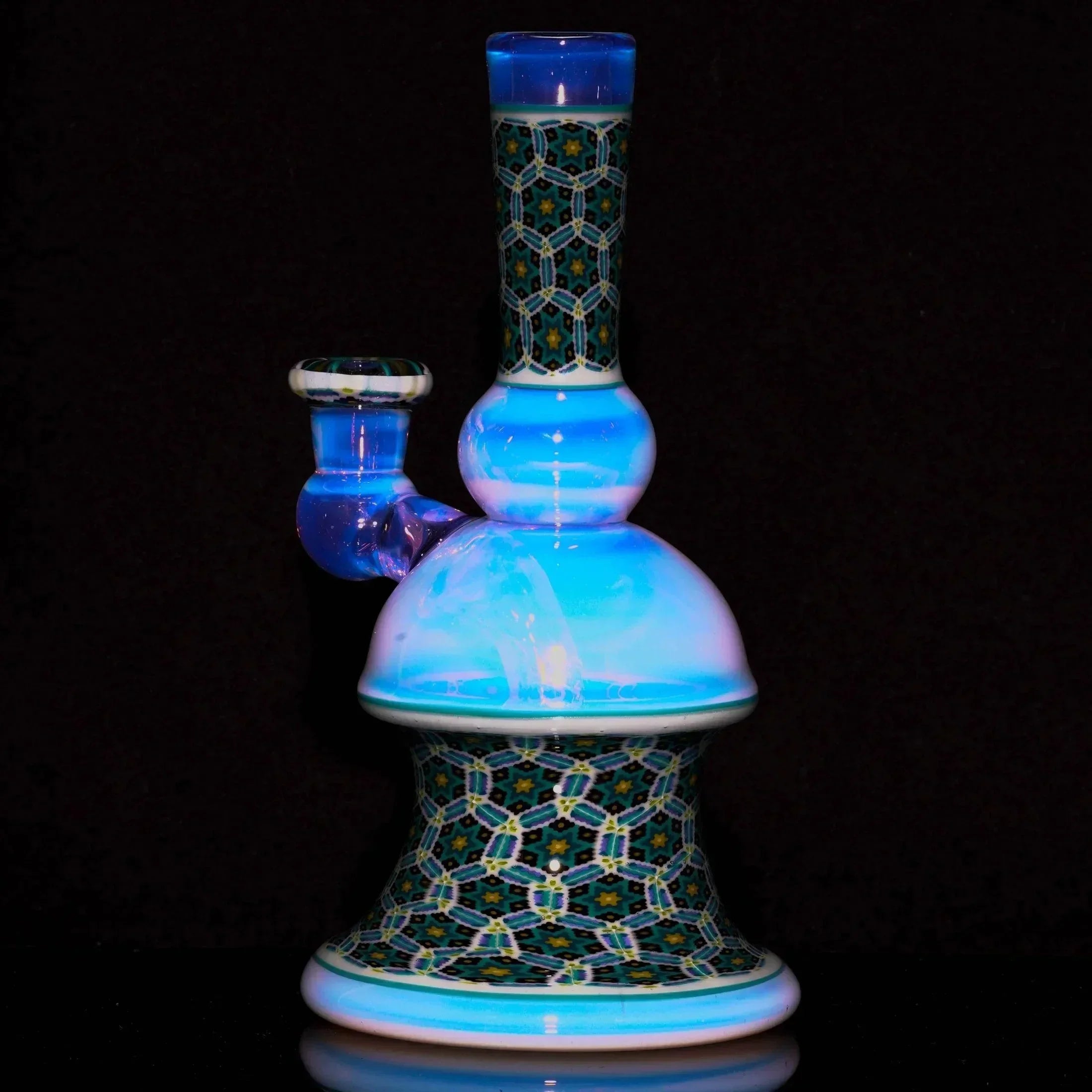 Intricate heady glass water pipe with geometric patterns and iridescent blue accents