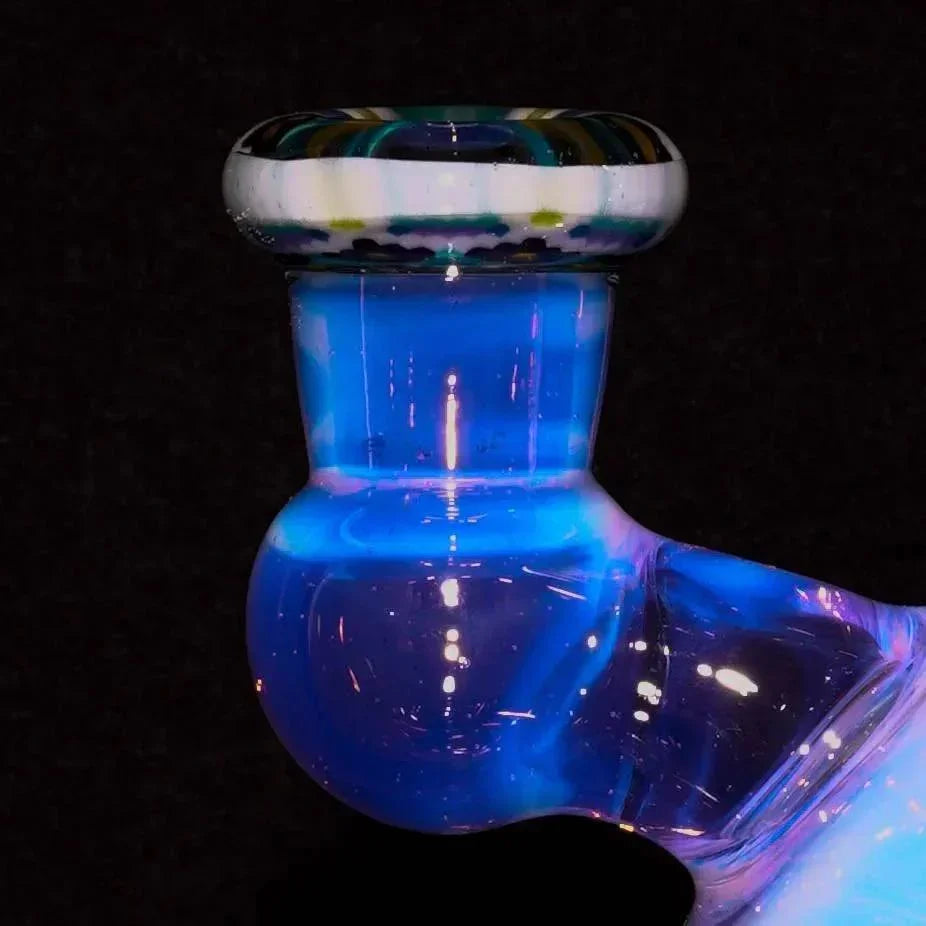Close-up of iridescent glass pipe with blue luminescence and colorful rim on black background