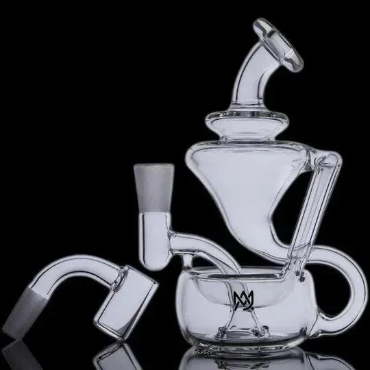 Clear glass recycler dab rig with detachable quartz banger on black background
