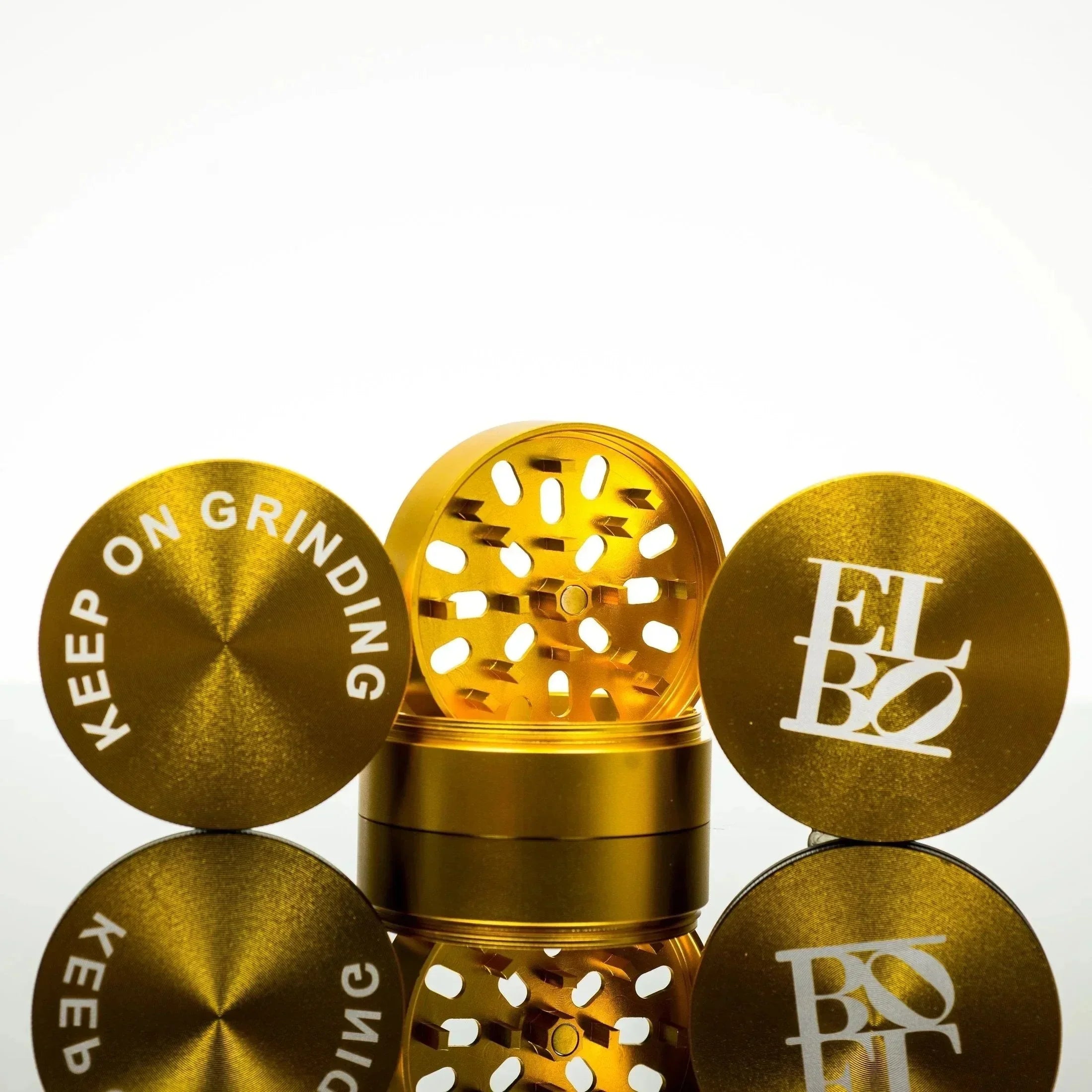 Gold ELBO grinder with 'Keep On Grinding' lid, premium smoking accessory