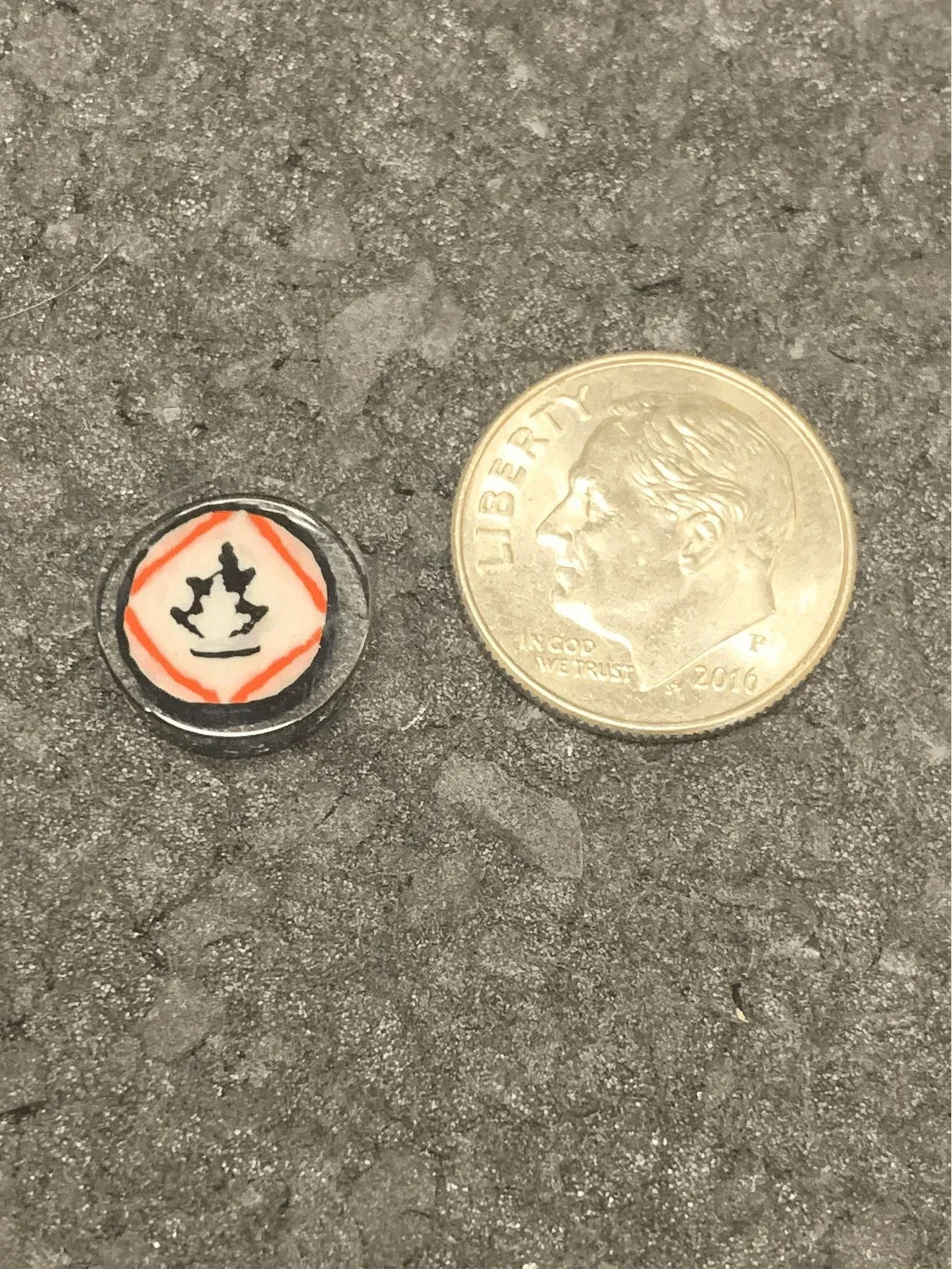 Mini glass pipe bowl with crown design, shown next to dime for scale, heady glass accessory