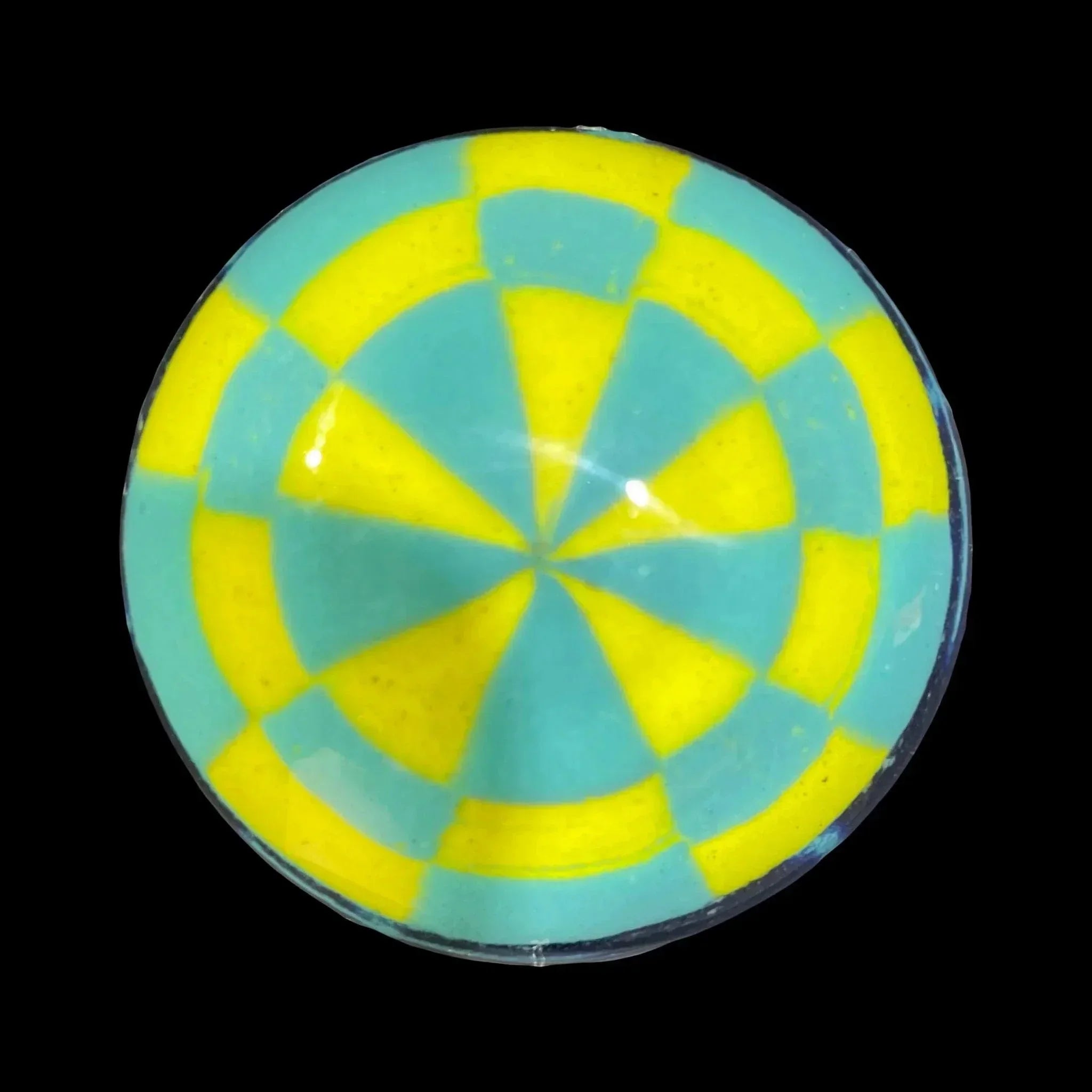 Round glass carb cap with blue and yellow geometric spiral pattern on black background