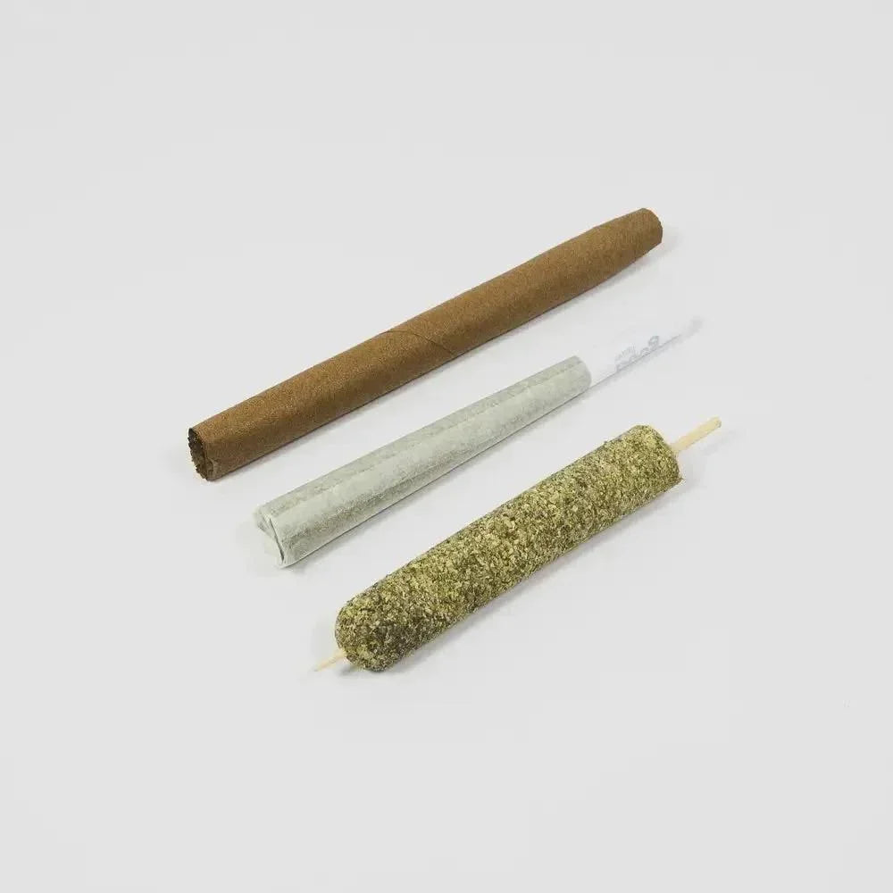Three rolled smoking products including a blunt, pre-rolled cone, and coated joint on white background