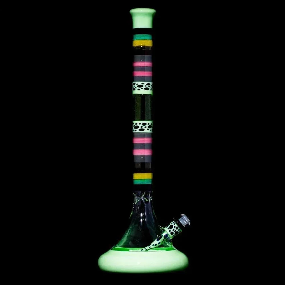 Colorful glass water pipe with neon bands and spotted patterns on a black background