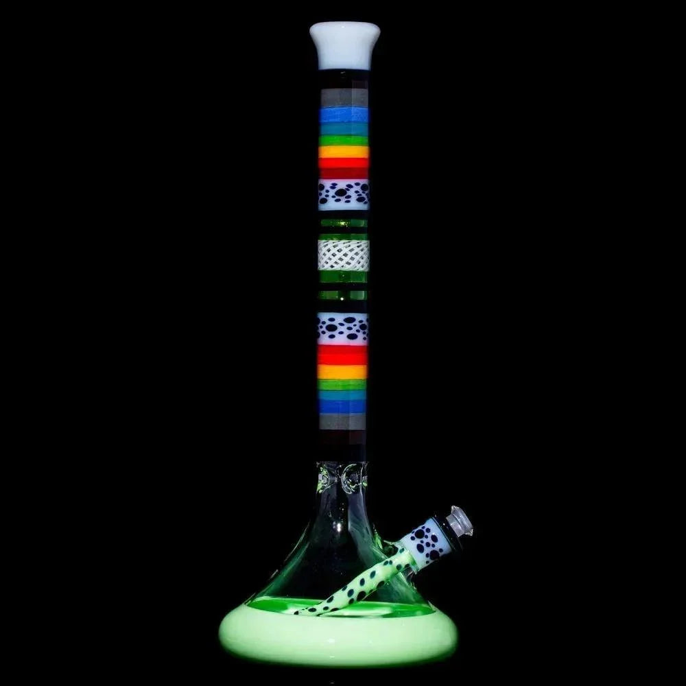 Glass water pipe with rainbow stripes and glow-in-the-dark base on black background