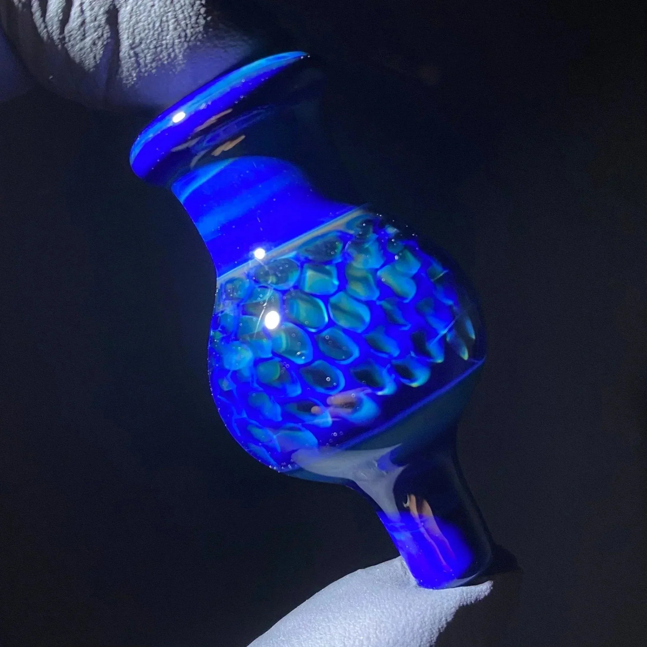 Hand holding a blue textured glass bowl with honeycomb pattern, heady glass accessory