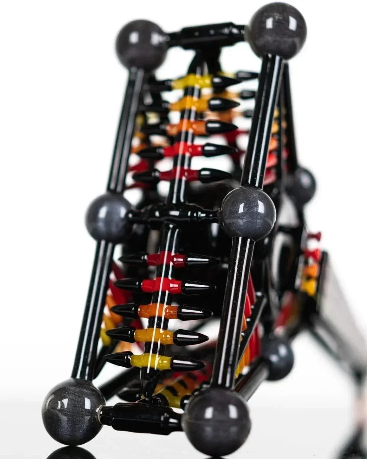 Artistic glass pipe with black, red, and yellow accents, featuring intricate design and spherical joints.