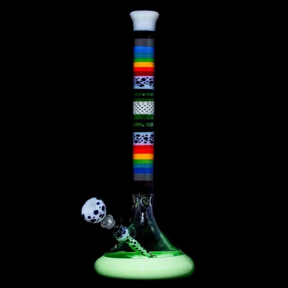 Colorful glass water pipe with rainbow stripes and polka dot accents on a black background