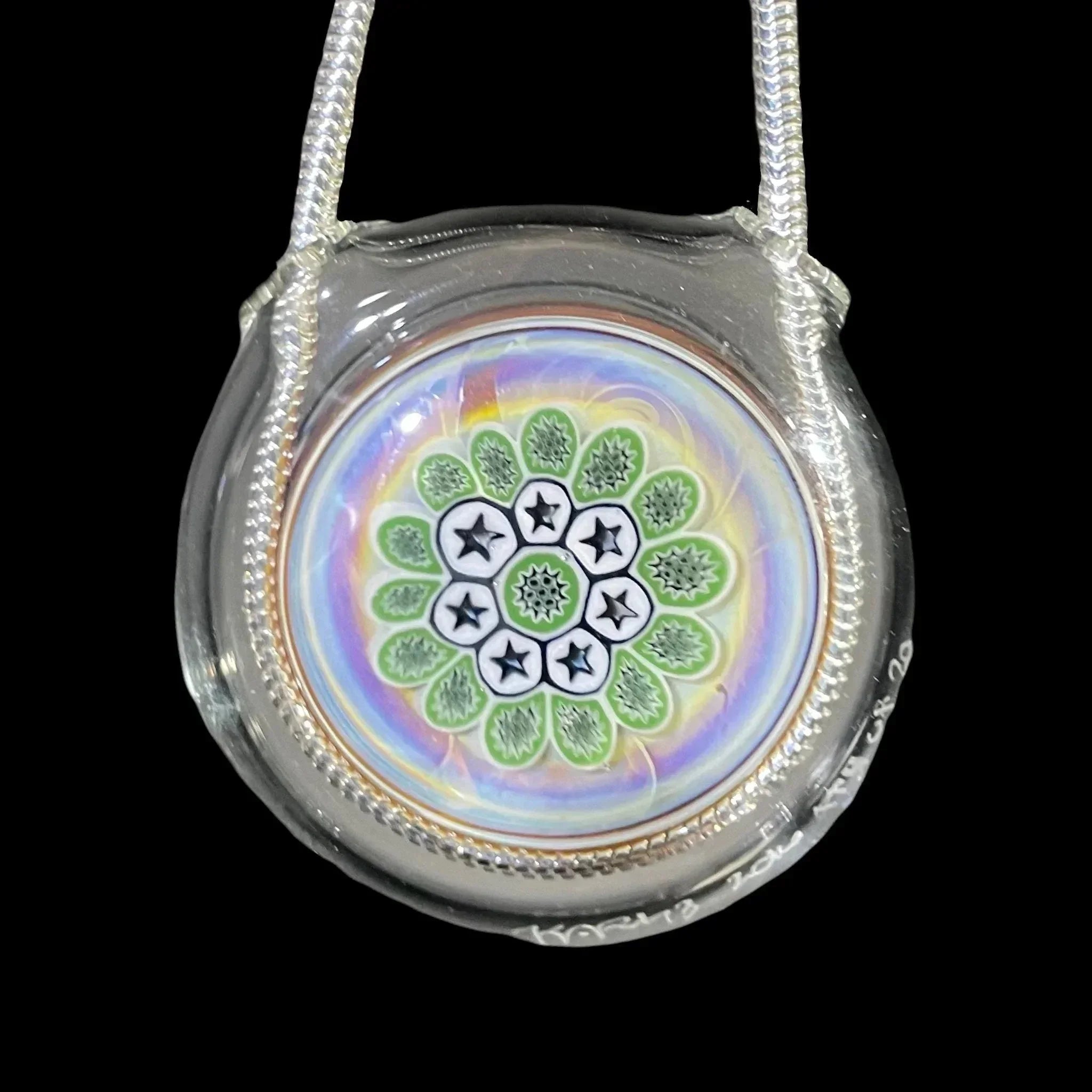 Colorful glass pendant with star and leaf pattern, encased in clear glass on a rope necklace