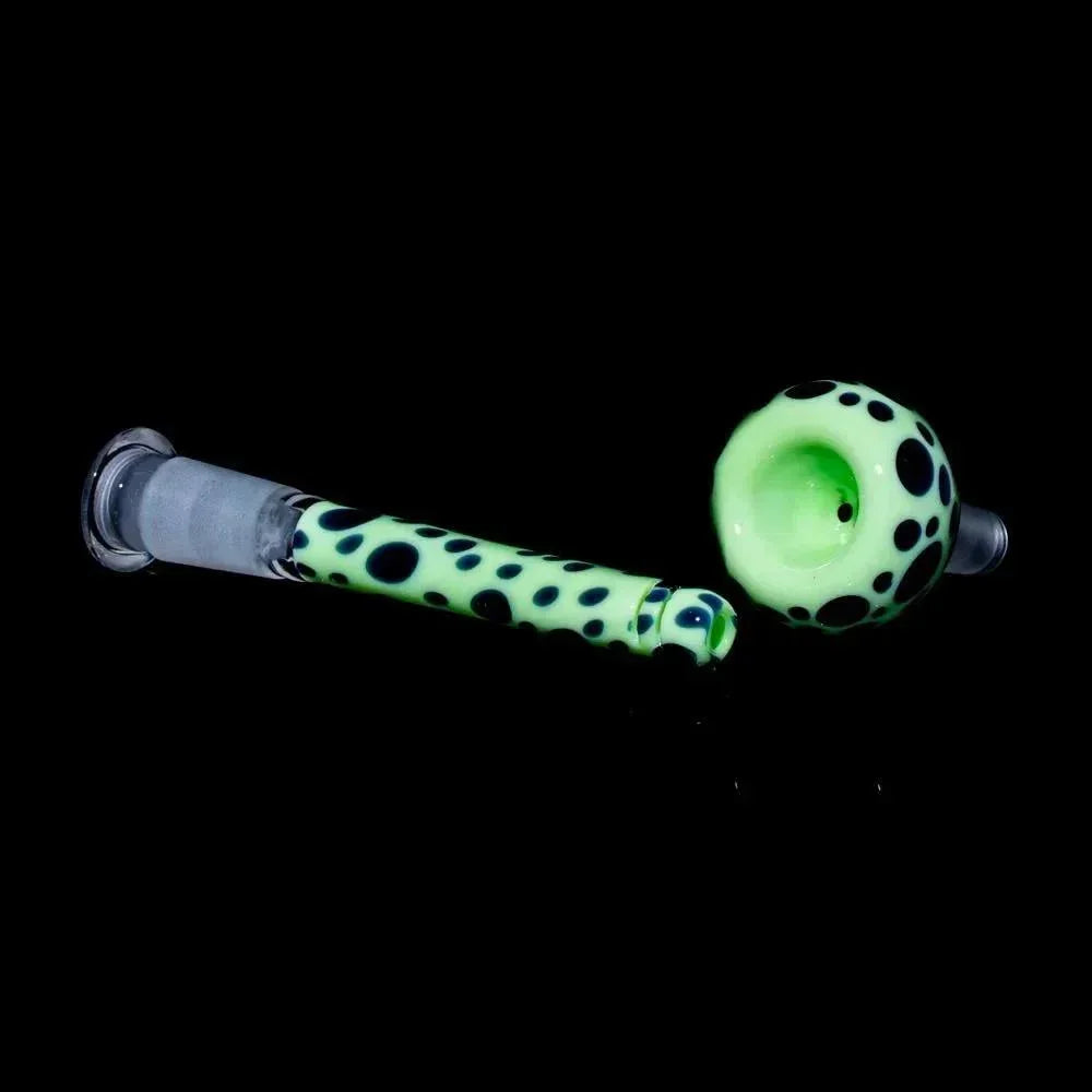 Glow-in-the-dark glass bowl and downstem with black polka dot design on black background