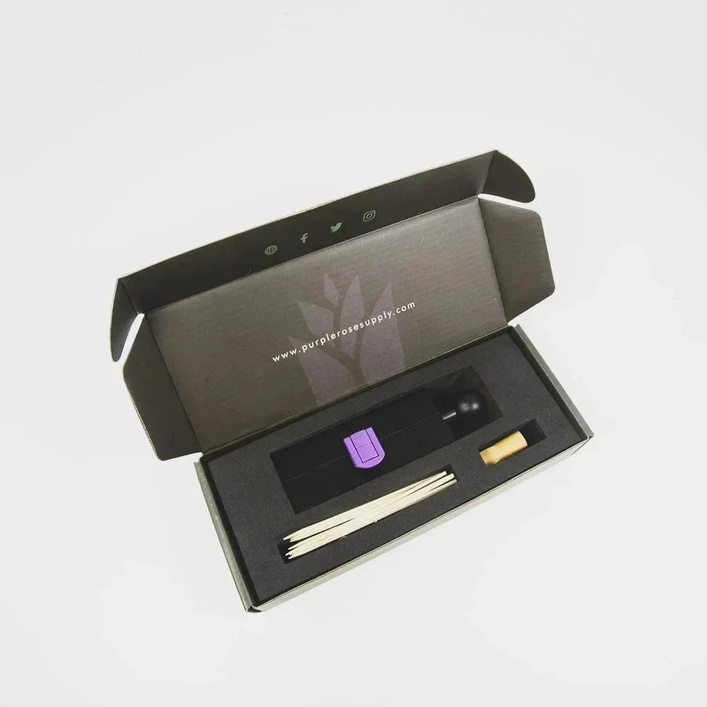 Glass blunt kit with black and purple roller, wooden sticks, and cork in foam-lined box