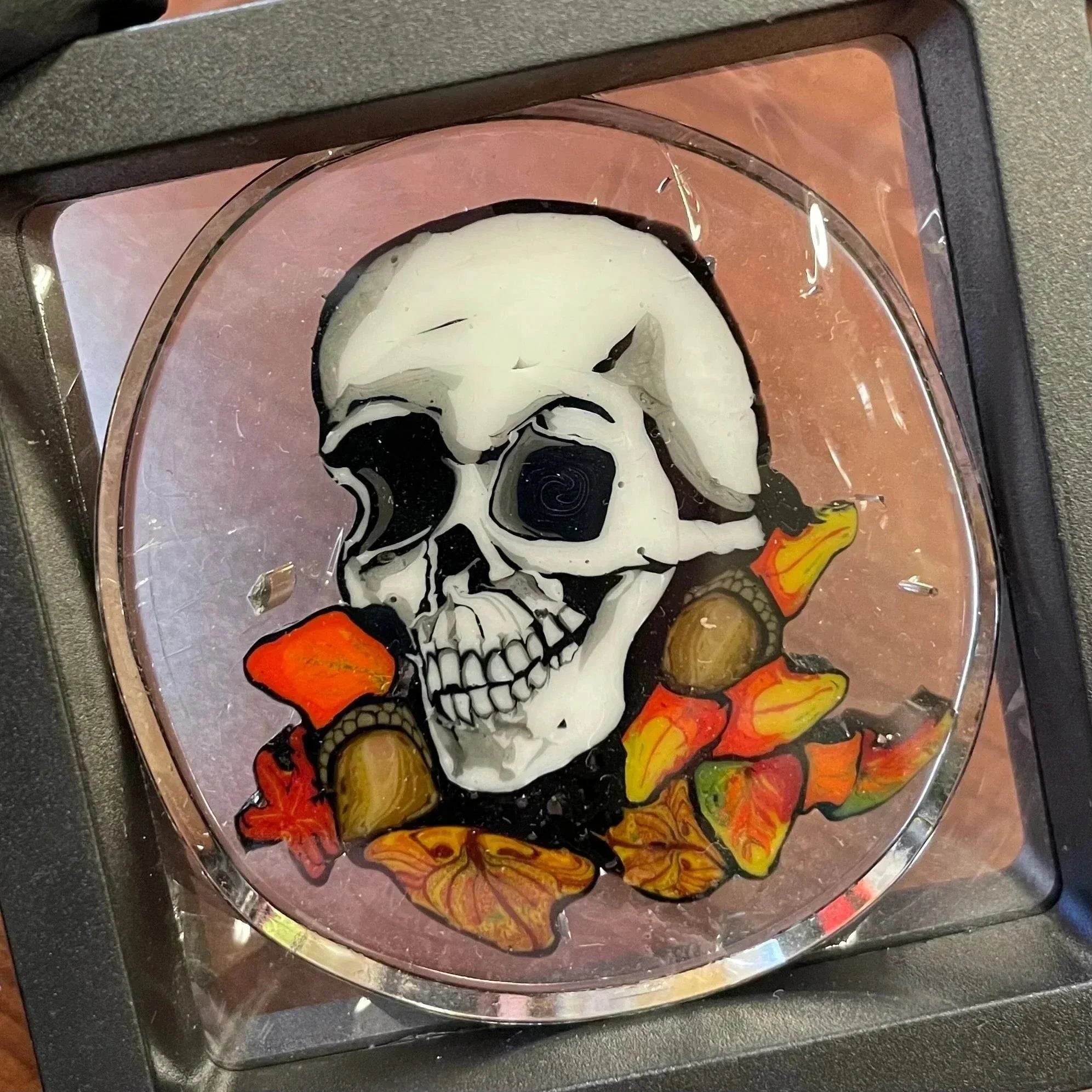 Glass art pendant with detailed skull and colorful mushrooms design