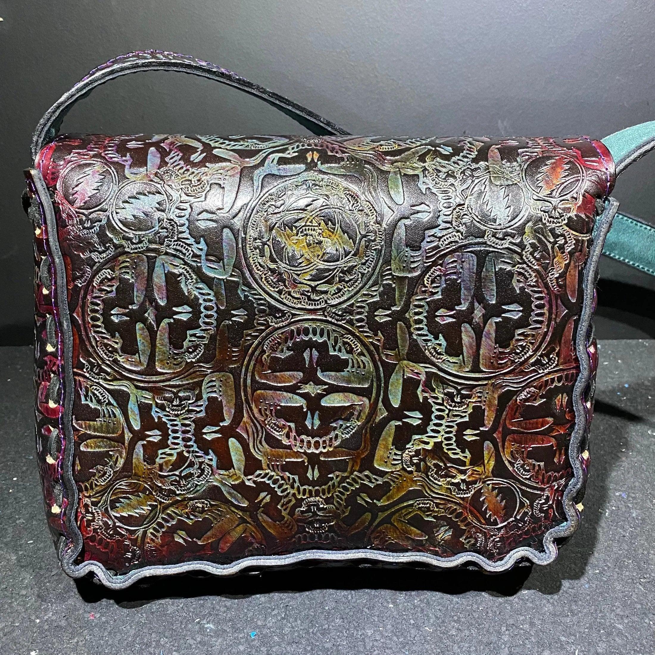 Handcrafted leather shoulder bag with embossed psychedelic skull and symbol patterns