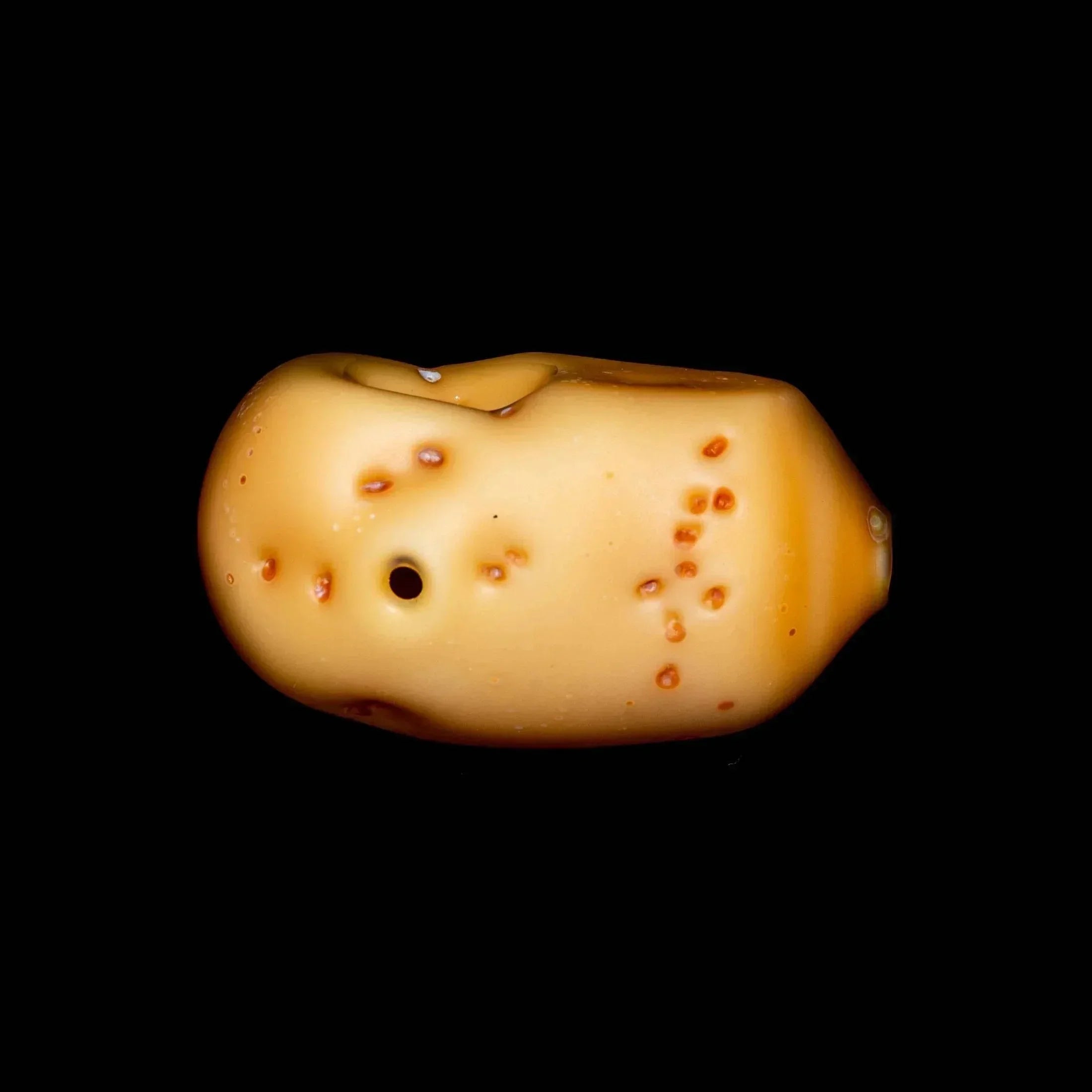 Realistic potato-shaped glass hand pipe with textured details on black background