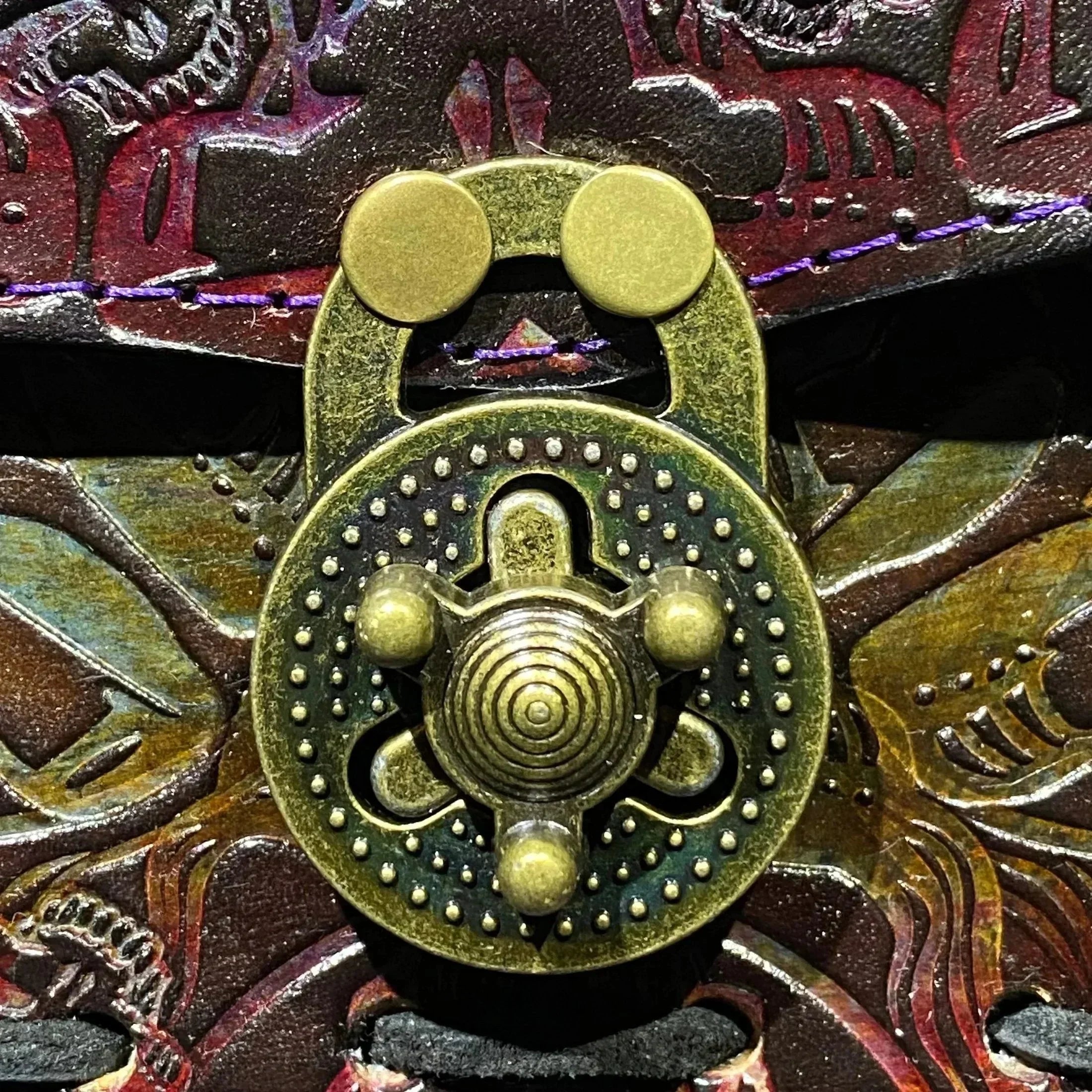 Close-up of ornate antique brass lock on carved wooden box lid