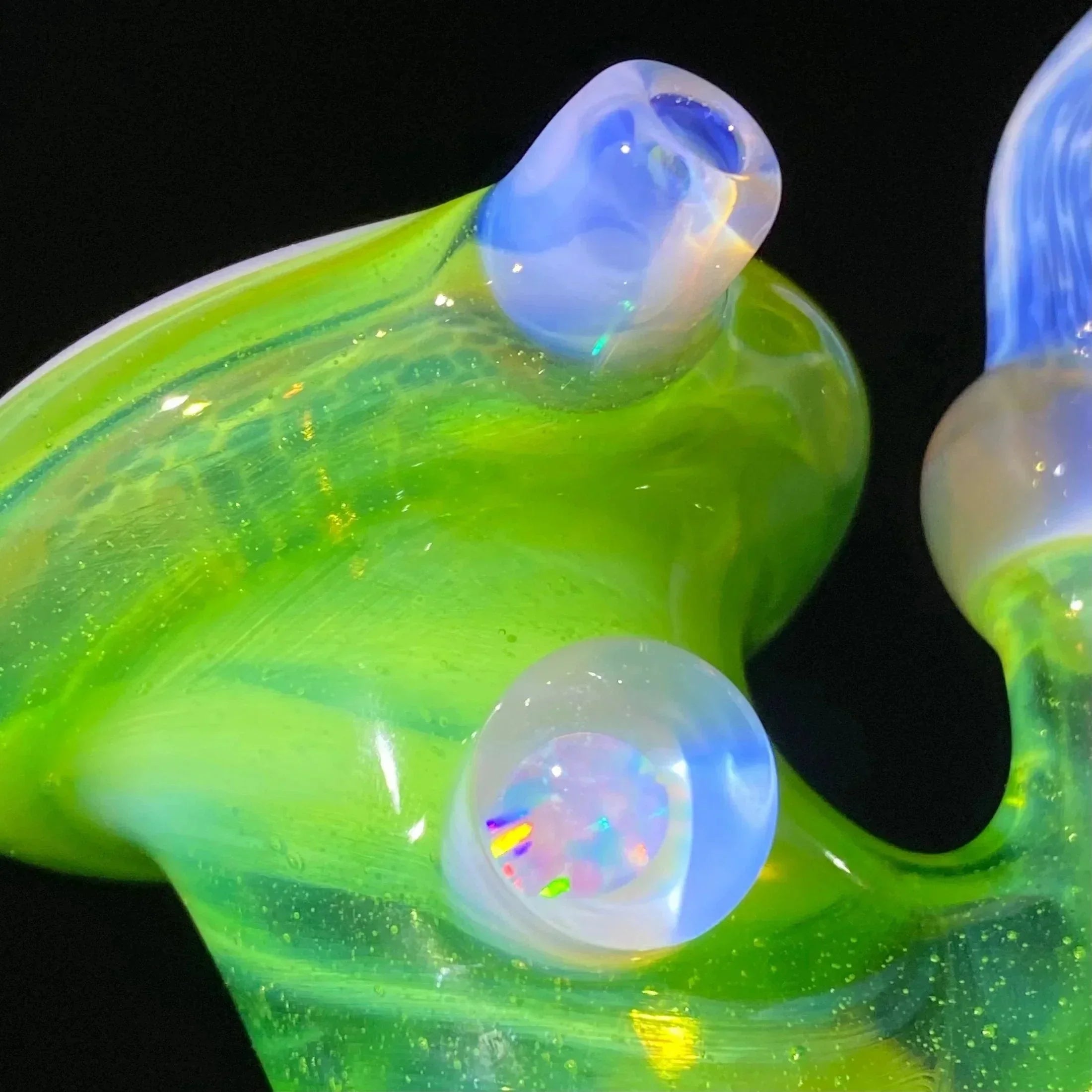 Close-up of green and blue heady glass with opal marble accent, blown glass art piece