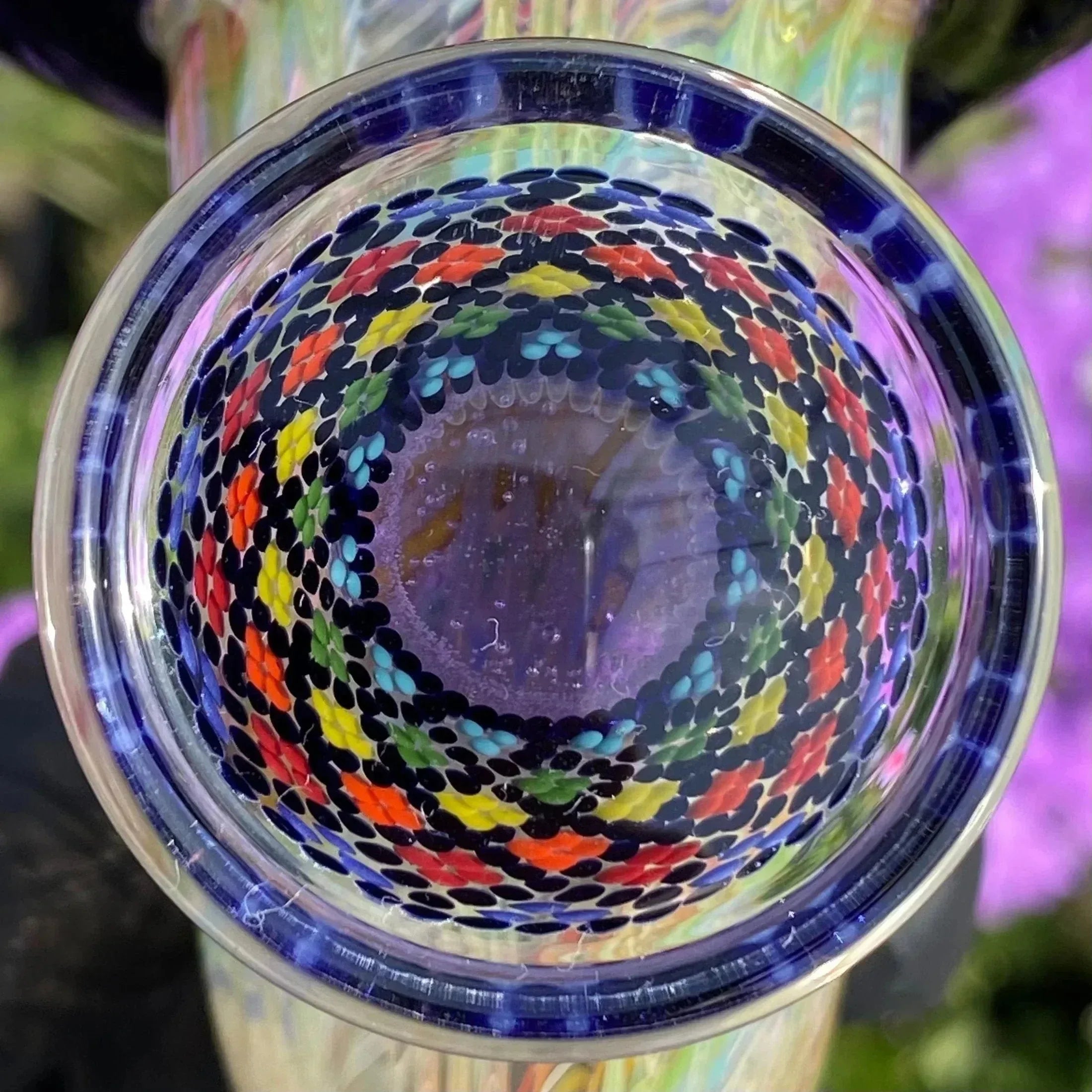 Close-up of a colorful glass pipe with intricate dot pattern in spiral design