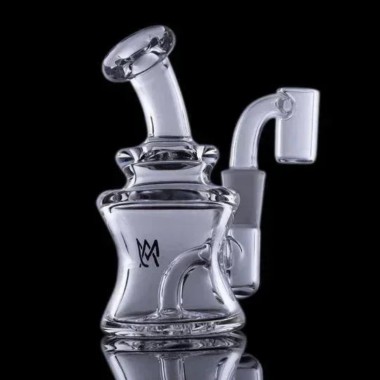 Clear glass recycler dab rig with bent neck and quartz banger on black background