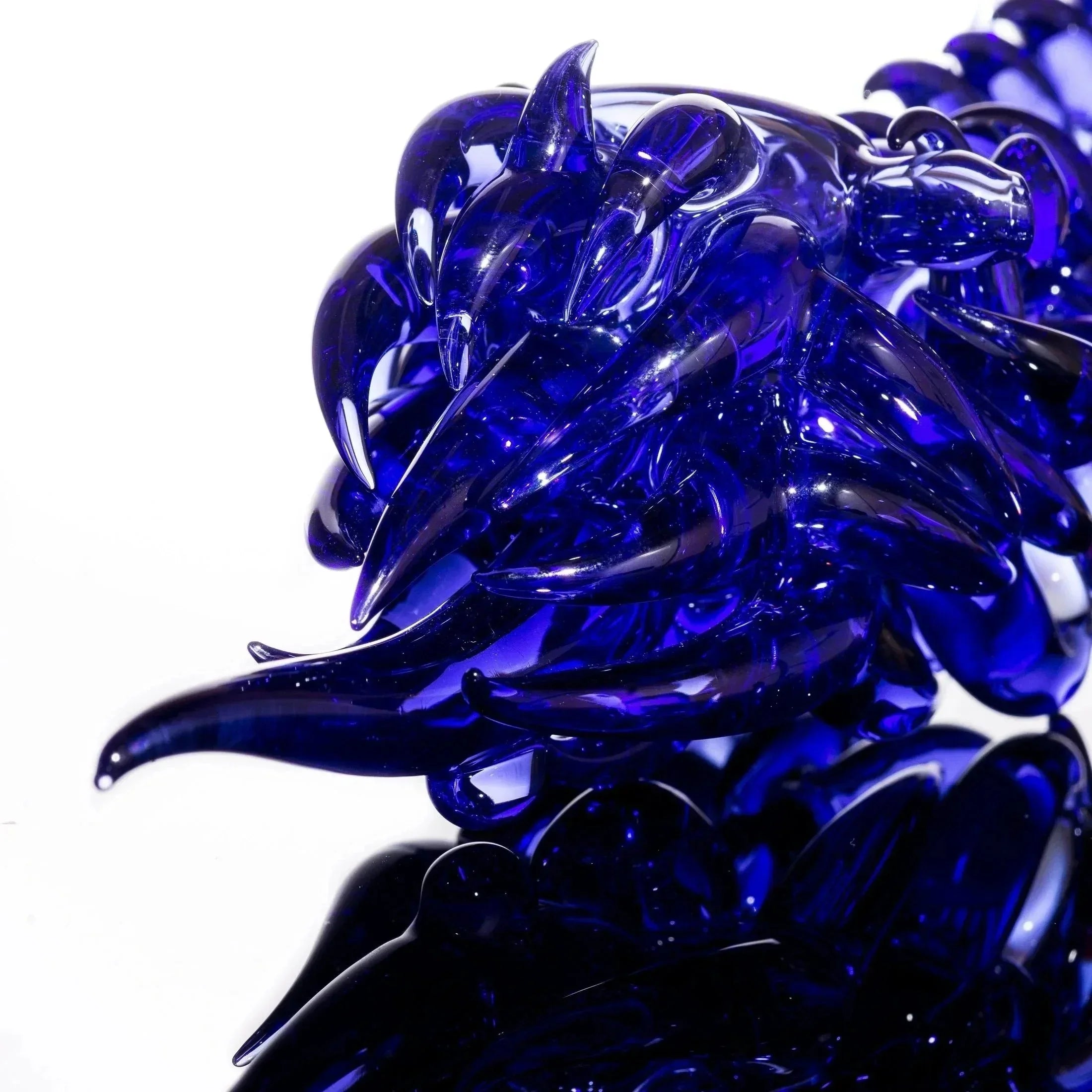 Deep blue hand-blown glass sculpture with intricate spikes and swirls, showcasing heady glass artistry.