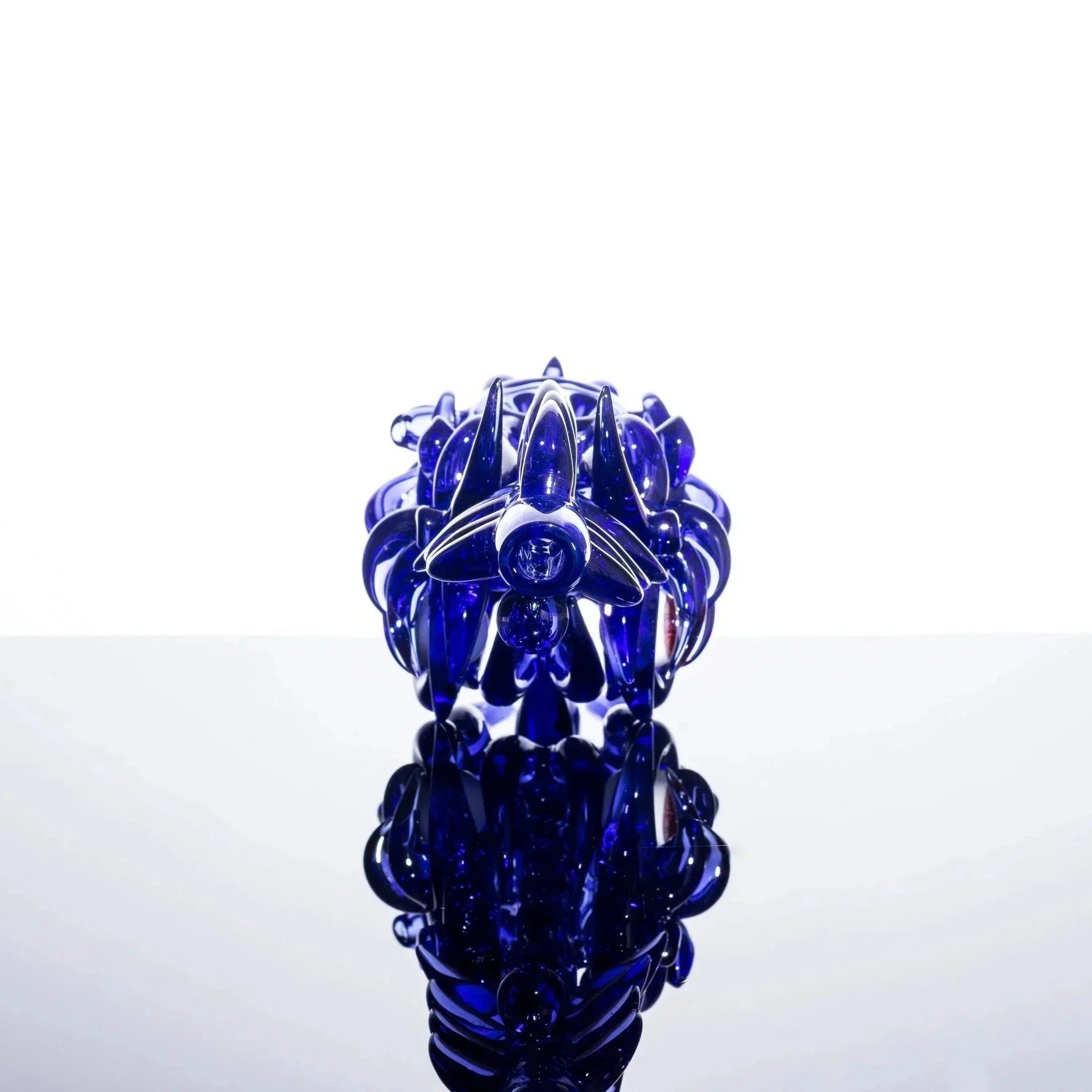Deep blue heady glass pipe with intricate floral design and reflective surface