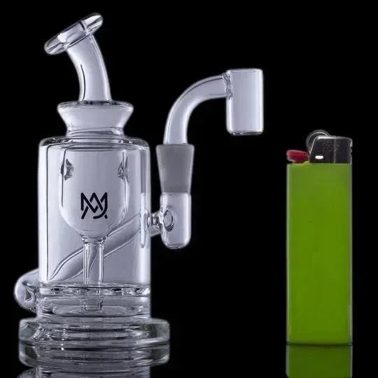 Clear glass mini dab rig with quartz banger next to a green lighter on a black background