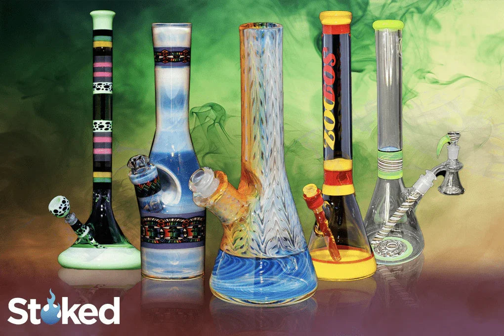 Colorful glass water pipes and bongs in a smoke-filled display, various sizes and patterns