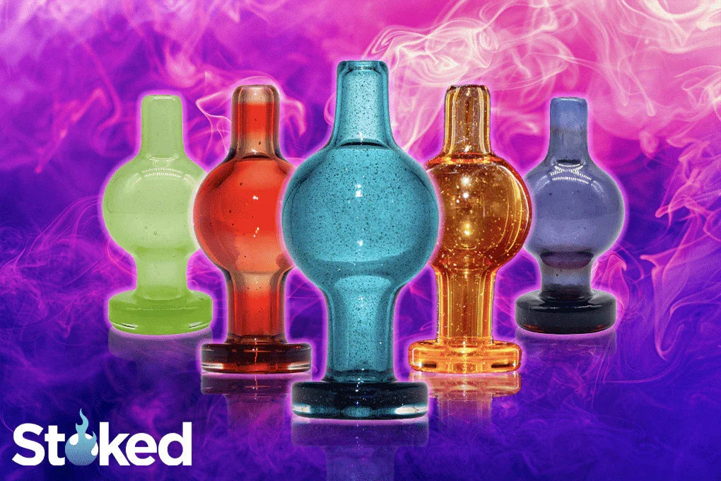 Colorful glass carb caps for vaporizers and glass accessories on a vibrant smoky background