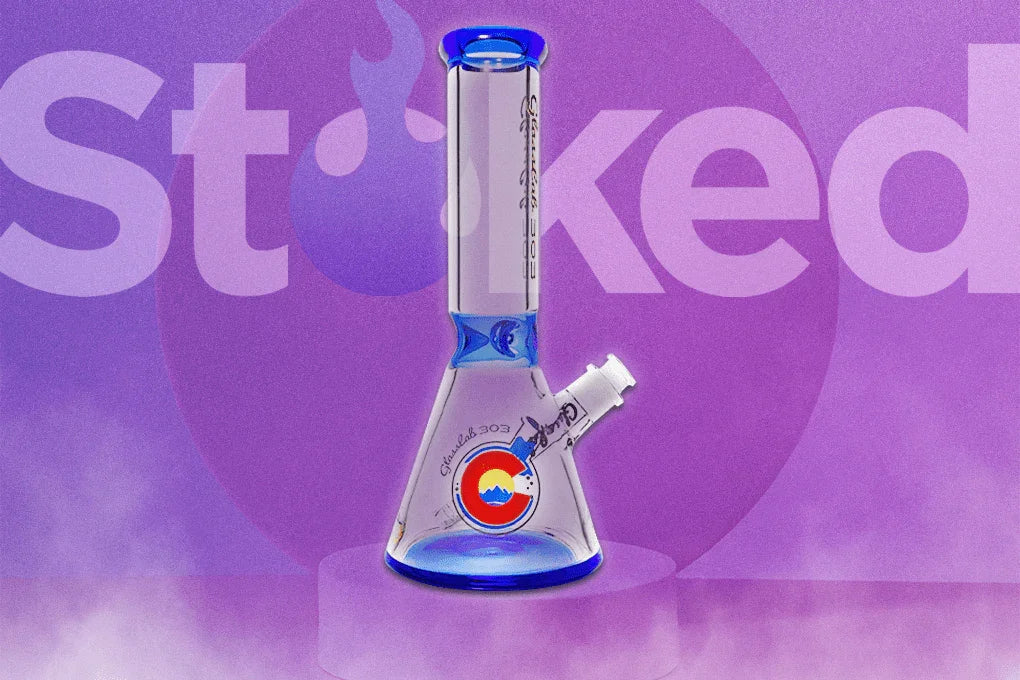 Blue glass beaker bong with Colorado logo, displayed on a purple smoky background
