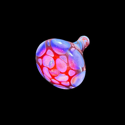 Colorful glass carb cap with red and purple bubble pattern on black background