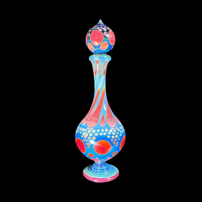 Colorful heady glass art piece with red, orange, and blue patterns on black background