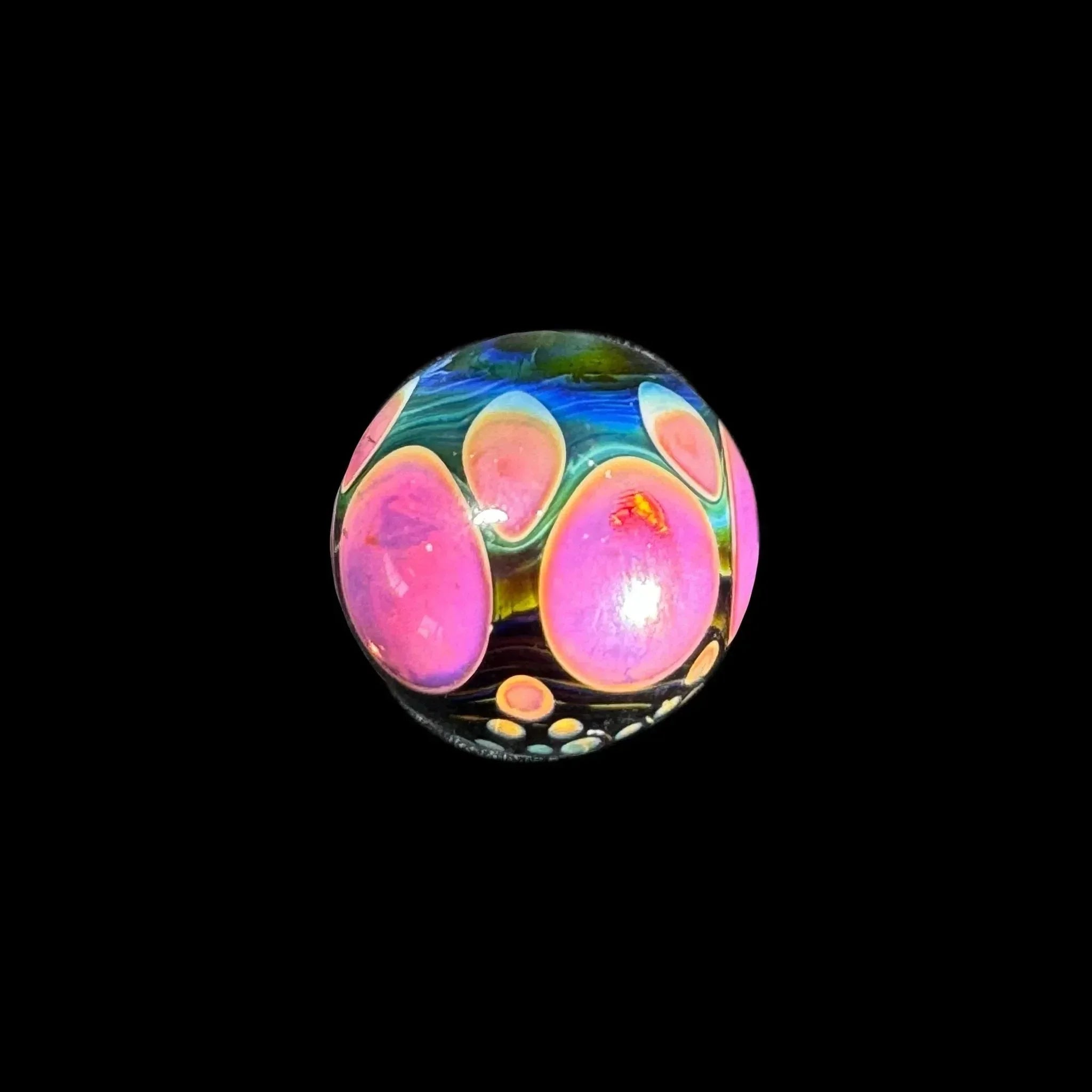 Heady glass marble with vibrant pink and blue patterns on a black background