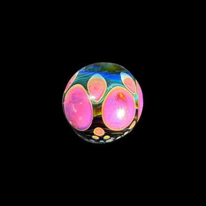 Heady glass marble with vibrant pink and blue patterns on a black background