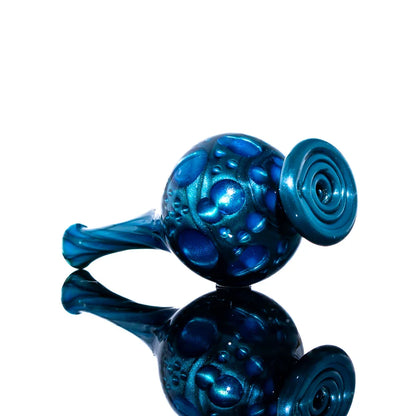 Blue textured glass hand pipe with bubble pattern, displayed on reflective surface