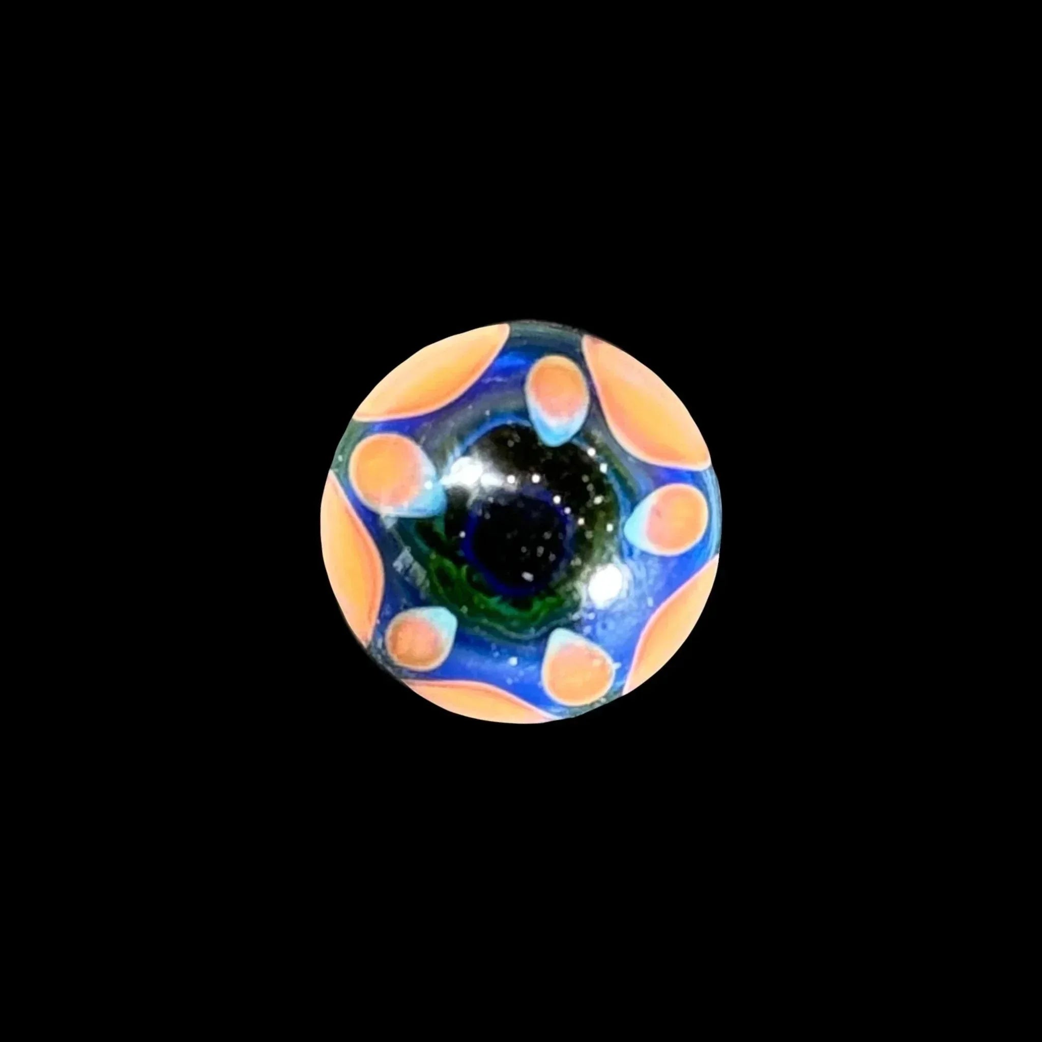 Hand-blown glass marble with orange and blue pattern on black background